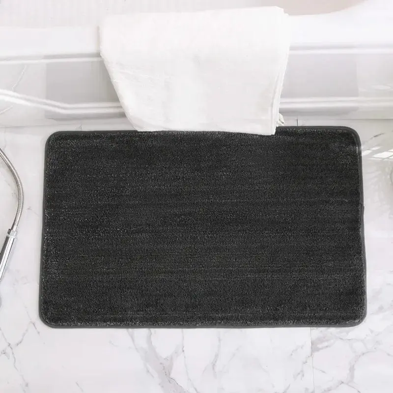 Schwarze Anti-Rutsch-Badematte im Badezimmer auf Marmorfliesen.