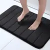 Schwarze Badematte Gross mit Fussabdruck, ideal für Badewanne und Badezimmer.