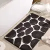 Schwarze Badematte mit Giraffenmuster aus Memory Foam, ideal für Badezimmer.