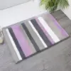 Runde Badematte mit Streifenmuster in Lila, Grau und Weiß fürs Badezimmer.