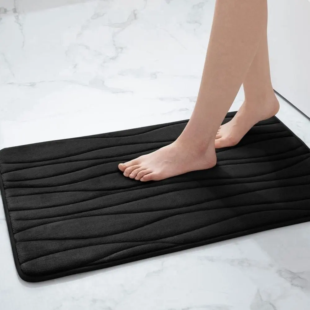 Schwarzer Badteppich mit welligem Muster, ideal für Badezimmer und Badematte.