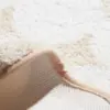 Weisse Badematte mit weichem Fleece-Bezug und rutschfestem Untergrund, ideal für Badezimmer.