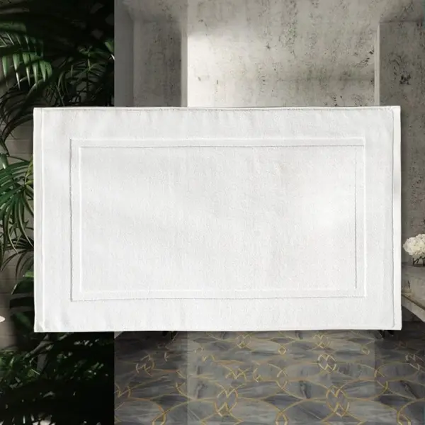 Weisser Badezimmerteppich aus Baumwolle mit gerahmtem Design, ideal für moderne Badezimmer.
