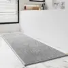 Grosser grauer Badteppich mit Struktur, ideal für Badezimmer mit Marmorfliesen.