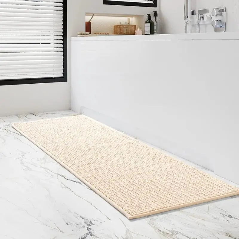 Grosser Badteppich in Creme mit strukturiertem Muster auf Marmorfliesen im Badezimmer.