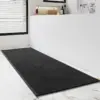 Schwarzer Badteppich Gross mit strukturiertem Design auf Marmor-Fliesen im Badezimmer.