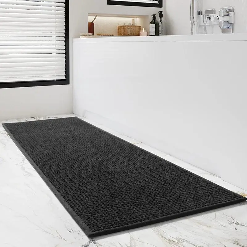 Schwarzer Badteppich Gross mit strukturiertem Design auf Marmor-Fliesen im Badezimmer.