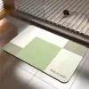 Rutschfester Badezimmerteppich mit geometrischem Muster in Grün-Weiss-Tönen, ideal für Nassbereiche.