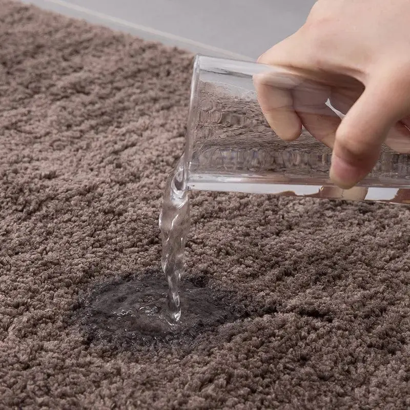 Schwarzer Badteppich mit Wasserprüfung – Wasserdicht und pflegeleicht im Badezimmer.
