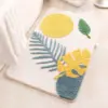 Skandinavischer Badezimmerteppich mit gelbem Sonnenmotiv und tropischen Blättern, weiches Material, ideal für Badezimmer.