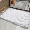 Weisser Badezimmerteppich mit Wellenmuster, weiches Material, ideal für Badezimmer.