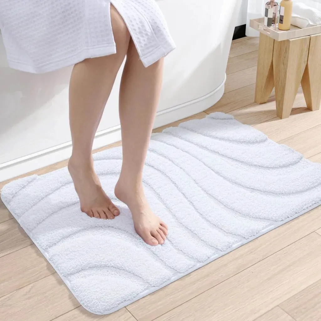Weisser Badteppich mit Wellenmuster, weiches Material, ideal für Badezimmer.
