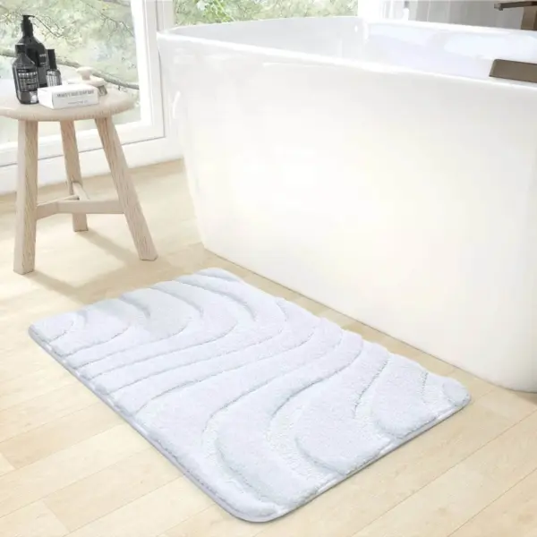 Weisser Badteppich mit wellenförmigem Muster, ideal für Badezimmer und Dusche.