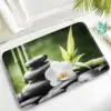 Badteppich mit Naturmotiv: weiße Orchidee, schwarze Steine und Bambus, ideal für Badezimmer.