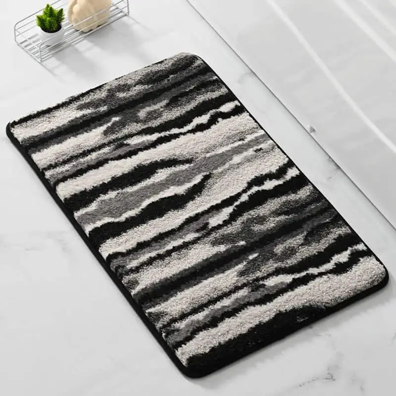 Schwarz-Weiss gestreifter Badteppich mit flauschigem Hochflor, ideal für Badezimmer.