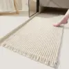 Badteppich Boho in Cremefarbe mit Fransen und strukturierter Webtechnik im Badezimmer.