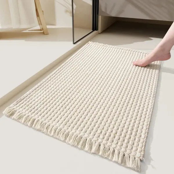 Badteppich Boho in Cremefarbe mit Fransen und strukturierter Webtechnik im Badezimmer.