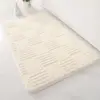 Weisser Badteppich mit geometrischem Muster, ideal für Badezimmer und Badematte.