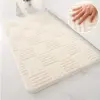 Weisser Badteppich mit geometrischem Muster, weiches Material, ideal für Badezimmer.