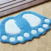 Blauer Badteppich in Fussform mit weißen Sohlen und Zehen, ideal fürs Badezimmer.