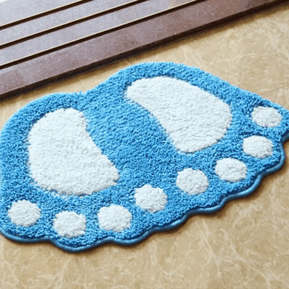 Blauer Badteppich in Fussform mit weißen Sohlen und Zehen, ideal fürs Badezimmer.