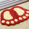 Badteppich Fussform rot mit cremefarbenen Sohlen, Badezimmer-Textil, Fußabdruck-Design.