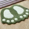 Grüner Badteppich mit Fussform, weisser Kontrast, für Badezimmer.