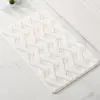Weisser Badteppich mit geometrischem Muster, weiches Material, ideal für Badezimmer.