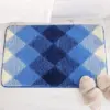 Badteppich mit blau-cremigem Karomuster, weiches Material, ideal für Badezimmer.