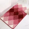 Badteppich mit rosa und rot schimmerndem Karomuster, weicher Hochflor-Textil für Badezimmer.