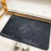Schwarzer Badteppich mit Palmenblatt-Muster, ideal für Badezimmer und Dusche.