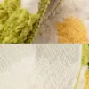 Badteppich aus Naturmaterial mit grünen Fransen und texturiertem Untergrund, ideal für Badezimmer.