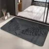 Schwarzer Badteppich mit Pflanzenmotiv, filziger Textur, modernes Badezimmer-Design.