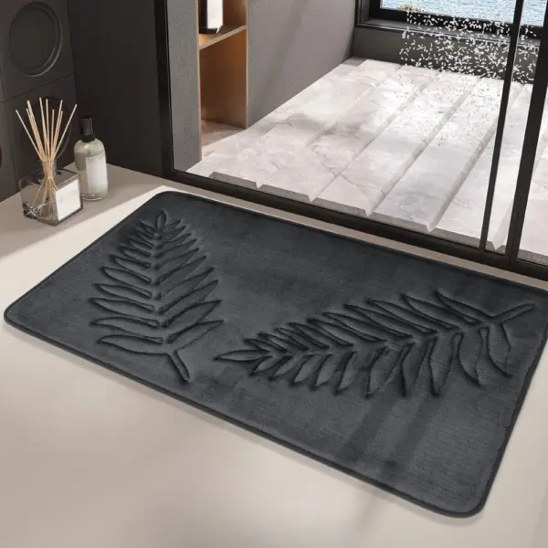 Schwarzer Badteppich mit Pflanzenmotiv, filziger Textur, modernes Badezimmer-Design.