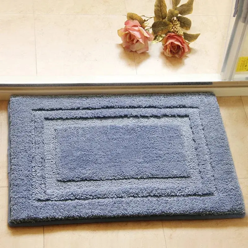 Blauer Badteppich mit Saugfähigkeit und Bordüre, ideal für Badezimmer.