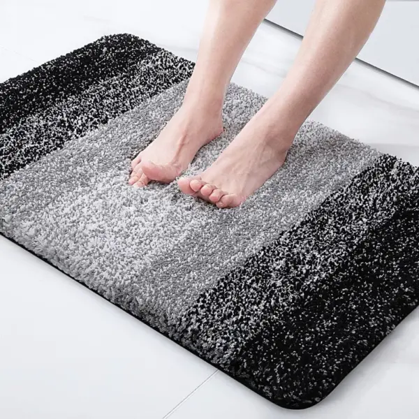 Heller Badteppich mit schwarzem Rand, weicher Textur, ideal für Badezimmer.
