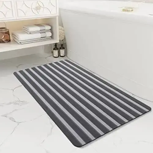 Grau-schwarzer gestreifter Badvorleger mit rutschfestem Boden, ideal für Badezimmer und Dusche.