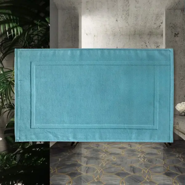 Blauer Baumwoll-Badteppich mit Bordüre, ideal für modernes Badezimmer.