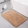 Beige Badteppich mit weichem Flor vor der Badewanne, ideal für Badezimmer.