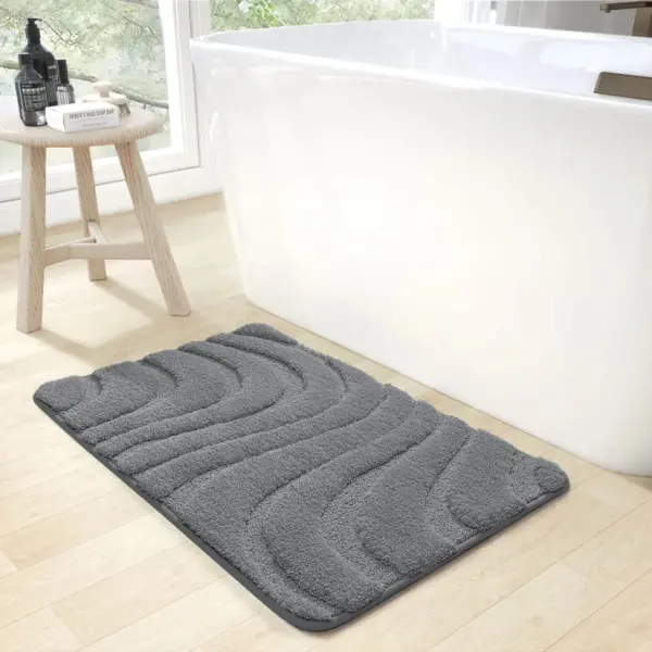Dunkelgraue Badematte mit wellenförmigem Muster, ideal für Badezimmer.
