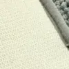 Dunkelgrüne Badematte mit strukturiertem Oberflächenmuster und weichem Fleece-Rand.