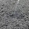 Dunkelgrüne Badematte mit Wasserstrahl, zeigt feuchtigkeitsresistente Oberfläche und hochwertiges Material.