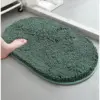 Dunkelgrüne Badematte mit Chenille-Struktur, weich und rutschfest im Badezimmer.