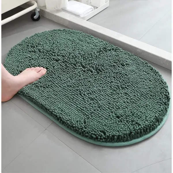 Dunkelgrüne Badematte mit Chenille-Struktur, weich und rutschfest im Badezimmer.