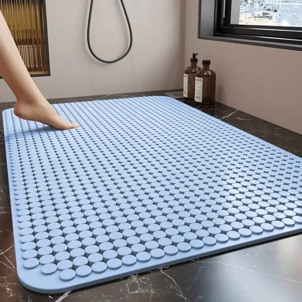 Blauer Badteppich mit rutschfesten Punkten, ideal für Duschbereich im Badezimmer.