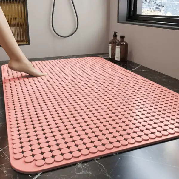 Pinkfarbene Duschmatte mit rutschfesten Punkten im Badezimmer.