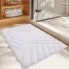 Flauschige Badematte weiss mit geometrischem Muster im Badezimmer.