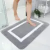 Grosse Badematte grau mit weissem Rand, weiches Material, ideal für Badezimmer.