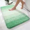 Grün-Weisse Badematte mit weichem Flor, ideal für Badezimmer und Dusche.