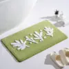 Olivgrüne Badematte mit weißen Blattmotiven, weiches Material, ideal für Badezimmer.